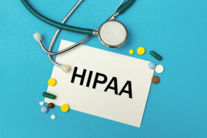 Card with the inscription HIPAA The Health Insurance Portability and Accountability Act of 1996, stethoscope and pills, top view